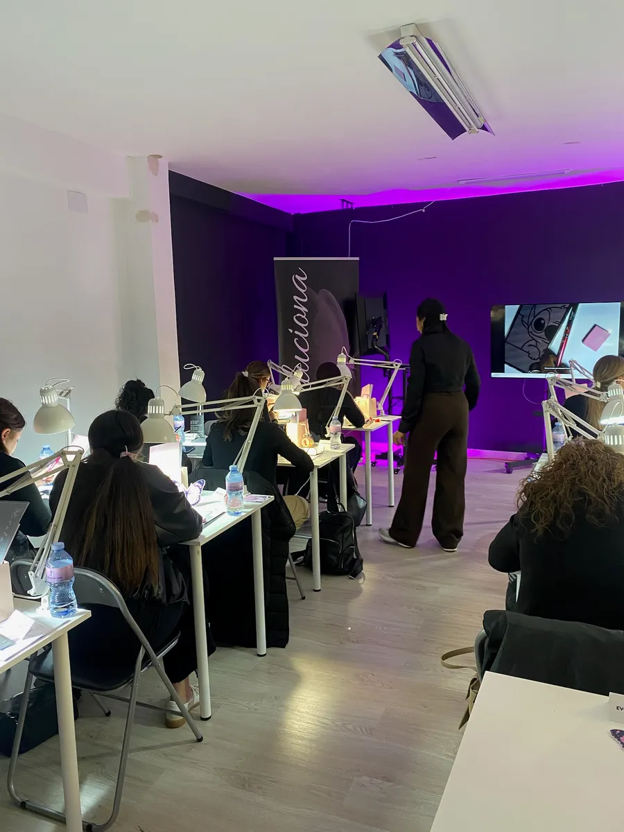 Sala llena de asistentes practicando manicura durante la formación Evoluciona